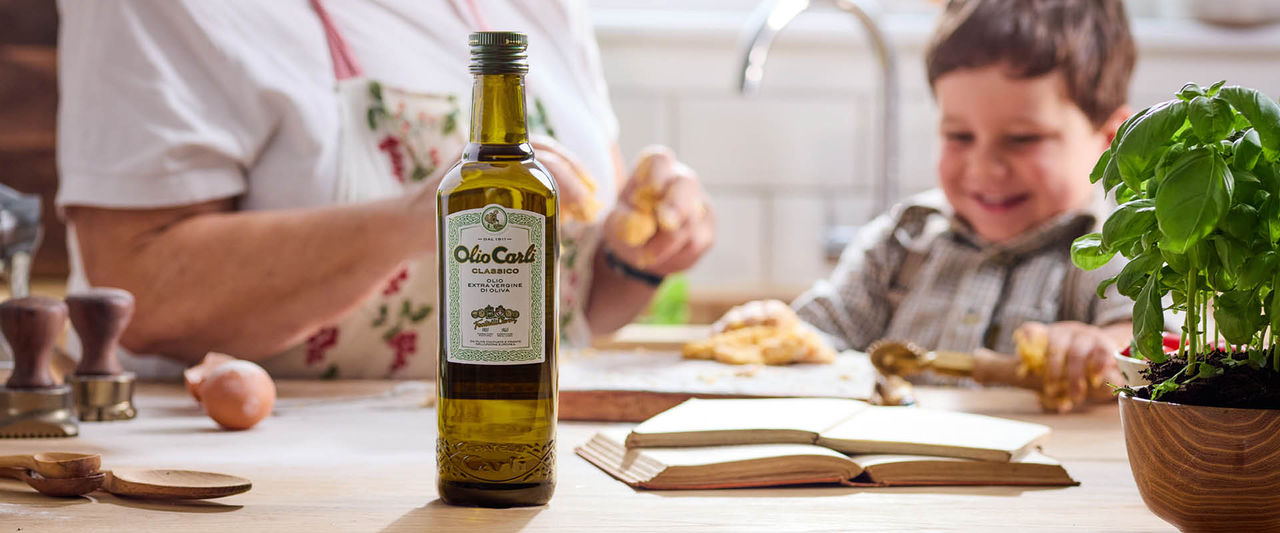 grand-mère et petite-fille cuisinant ensemble, avec au premier plan une bouteille d'huile