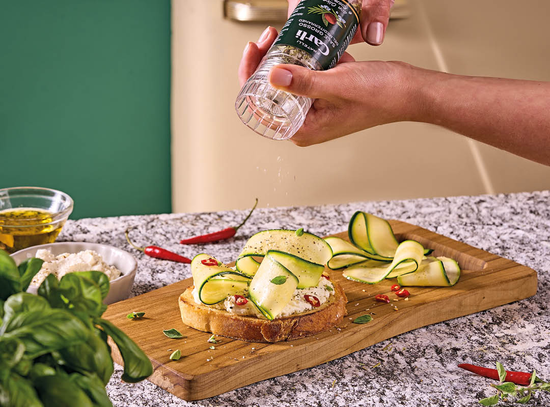 Personne utilisant un moulin à sel sur des zucchini