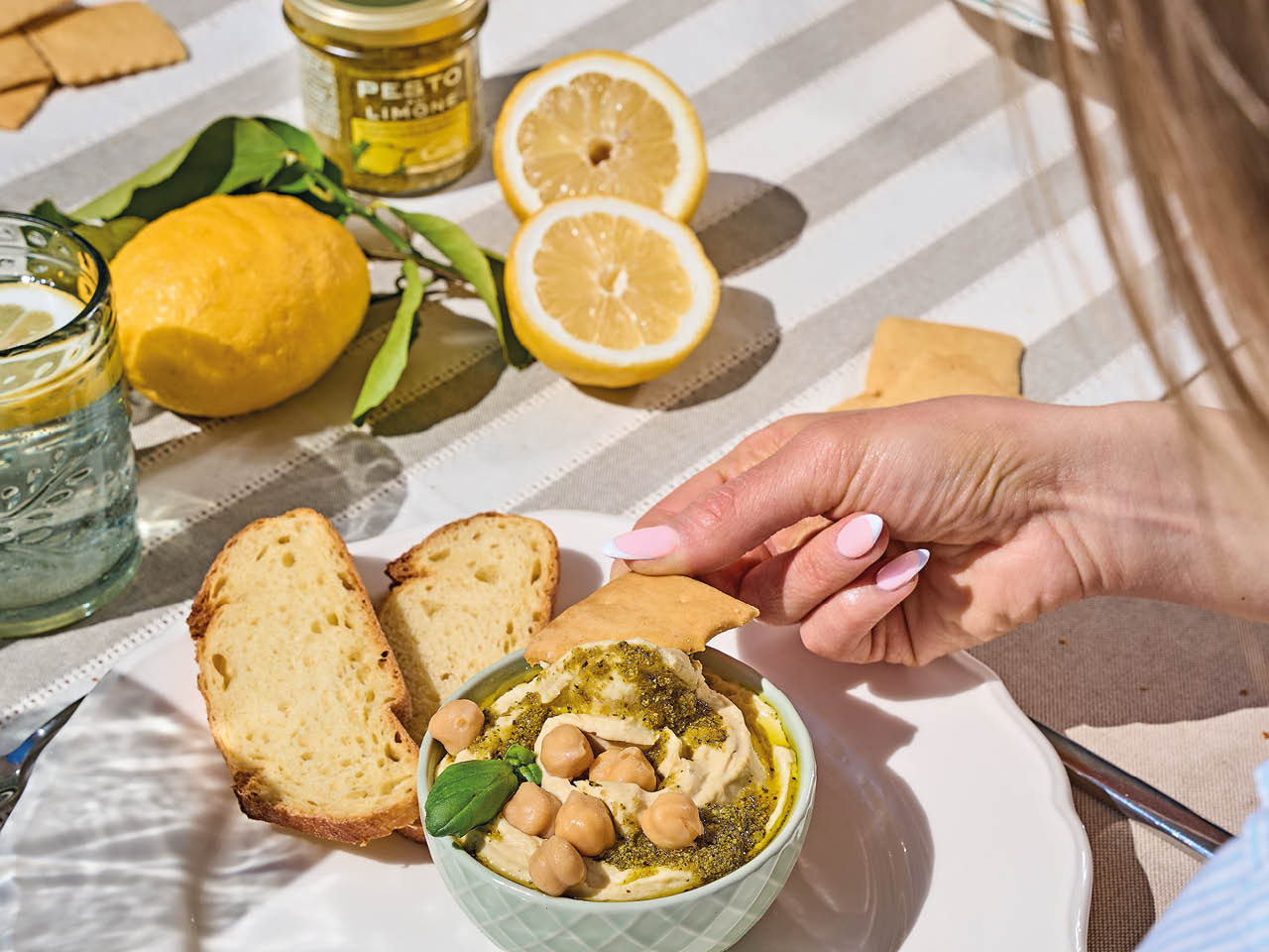 Jeune femme qui mange du hummus avec du pesto au citron