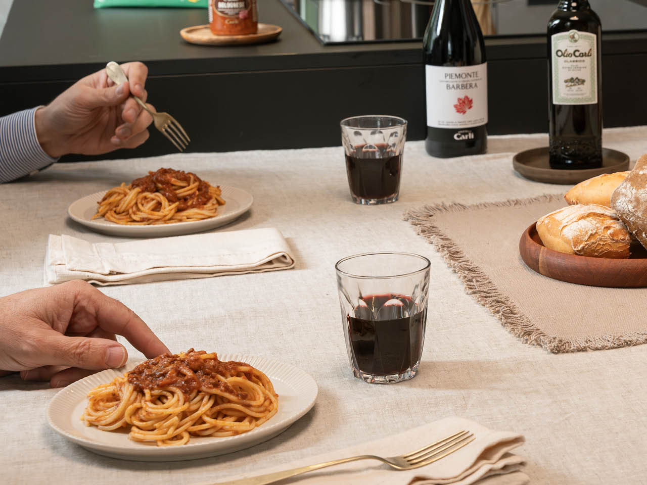 table avec des personnes assises qui mangent un plat de spaghetti à la bolognaise